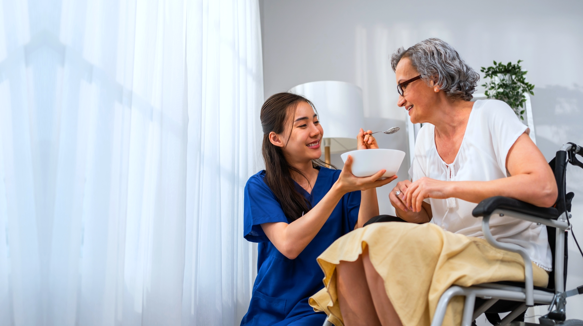 caregiver feeding the elderly woman